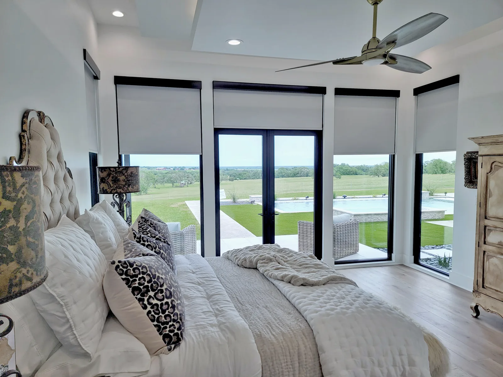 Soft white roller shades fitted to tall bedroom windows