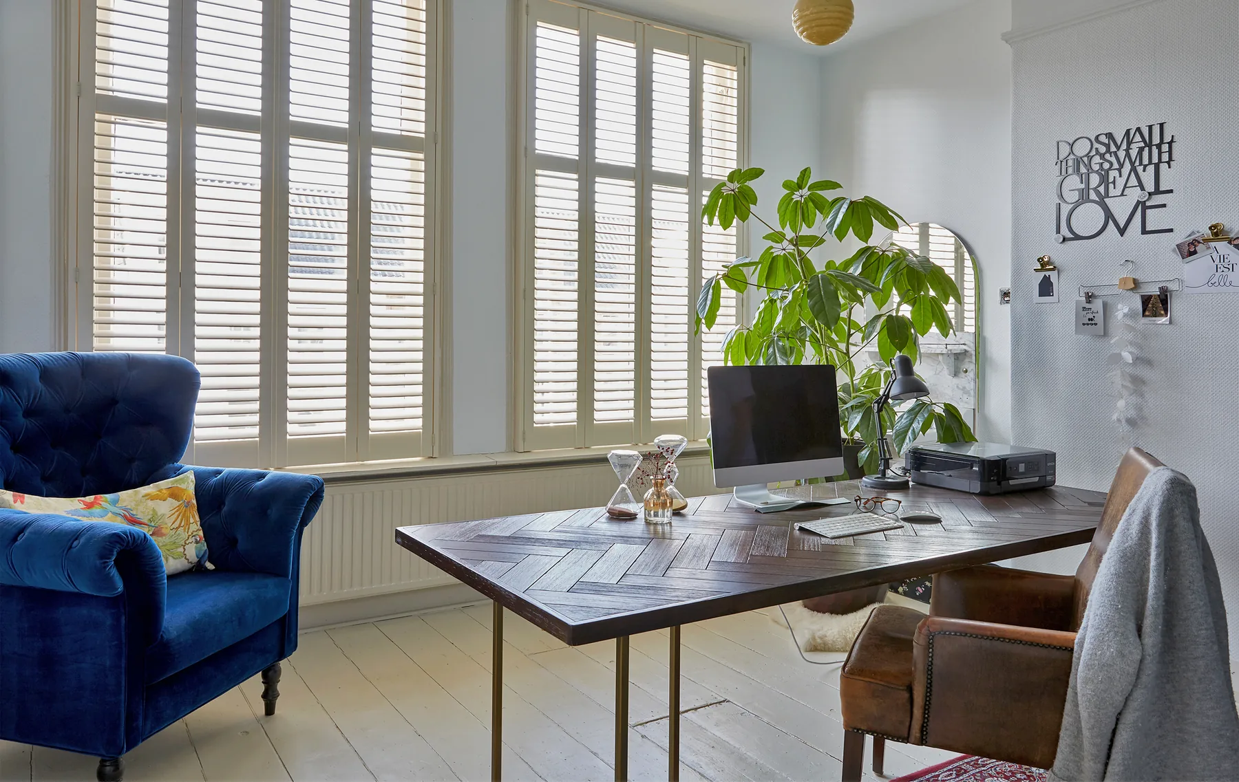 White plantation shutters fitted across tall interior windows